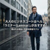 ヘルノ（HERNO）「ラミナー」のネイビーのコートを着こなすスーツ姿の男性。「大人のビジネスコートはヘルノ『ラミナー(Laminar)』がおすすめ！選ばれる理由と季節別鉄板モデル」と書かれたアイキャッチ画像。