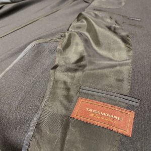 タリアトーレ(TAGLIATORE)のジャケットの内側を撮影したアップ画像。丁寧な仕立てがわかる裏地と内ポケットの下に、高級ラインの証である「TAGLIATORE SARTORIALE」と書かれた赤いブランドタグが縫い付けられている。