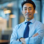 半袖シャツにネクタイの組み合わせがダサい・おかしいと感じるビジネスマンに向けて、解決策として推奨される長袖ドレスシャツをスマートに腕まくりした大人の夏の着こなしマナー