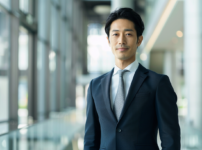 インフォーマル(平服)の指定で間違いのない、ネイビースーツとシルバーグレーネクタイを着用した大人のビジネスマンの正解スタイル