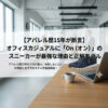 アパレル歴15年のプロが解説するブログ記事「オフィスカジュアルに『On（オン）』のスニーカーが最強な理由と正解モデル」のアイキャッチ画像。背景はぼかしたオフィスで、木目のデスクの上にノートパソコン、コーヒーカップ、そしてネイビーのOn（オン）スニーカー（Cloudモデル）が配置されている。