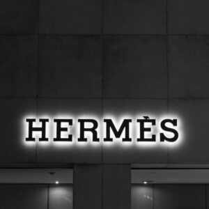 夜のエルメス店舗のモノトーン外観と光るブランドロゴ