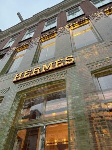 ガラスブロックの美しいファサードとゴールドのロゴが輝くエルメス店舗の外観